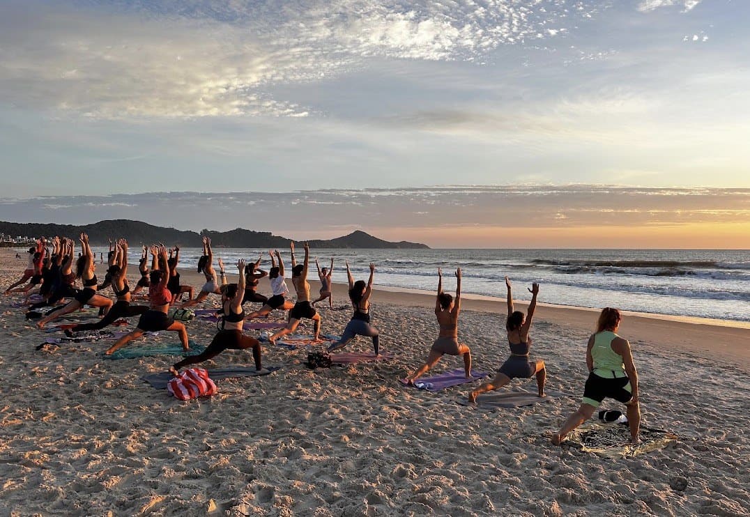 Prática de yoga na praia ao pôr do sol